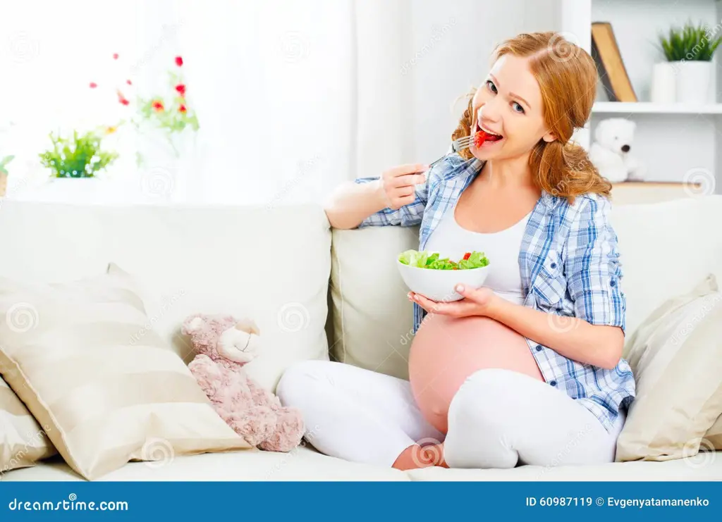 Gambar seorang wanita hamil yang sedang makan makanan sehat, termasuk pepaya