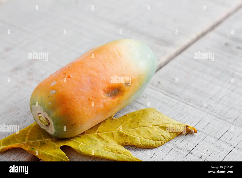 Gambar buah pepaya matang di atas meja kayu