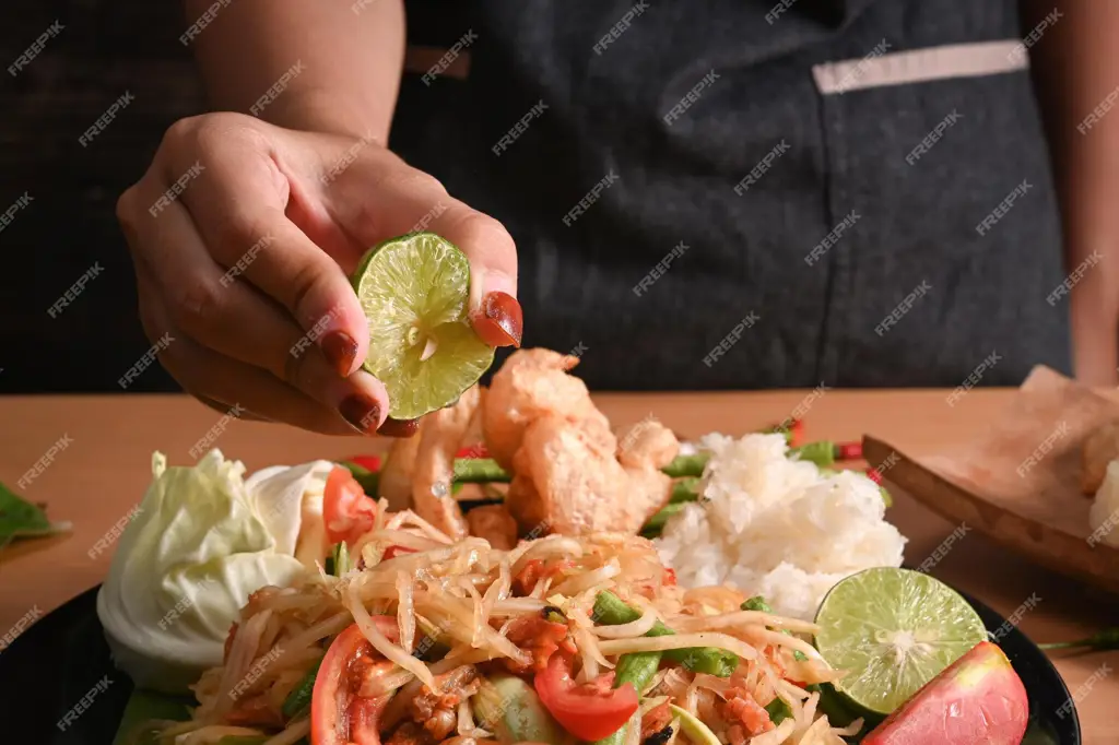 Seorang wanita sedang menikmati makan salad pepaya yang segar