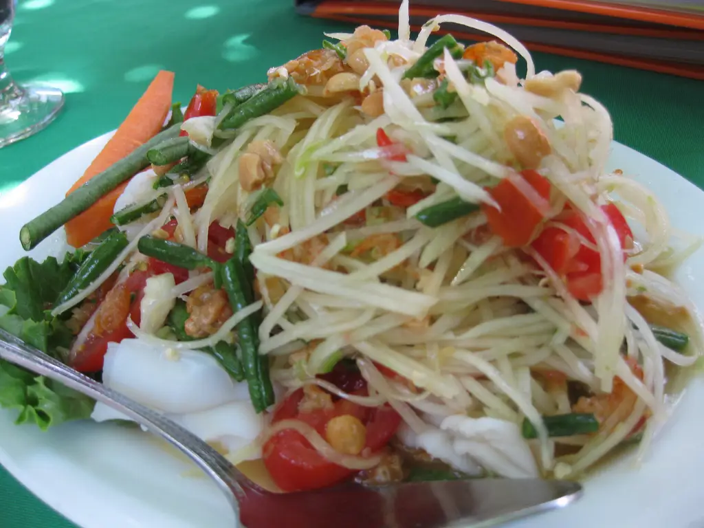 Lalapan daun pepaya disajikan dengan berbagai macam lauk pauk