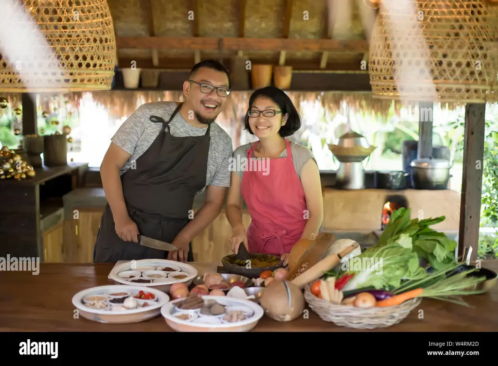 Seorang wanita sedang memasak bunga pepaya dengan bumbu khas Manado