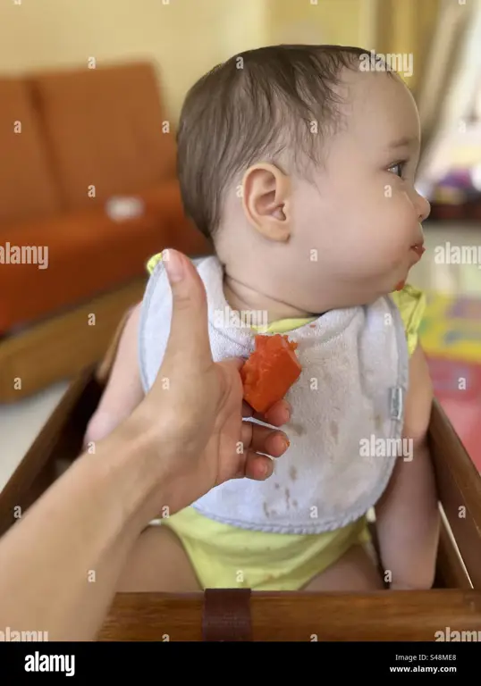 Seseorang sedang makan pepaya sendirian.