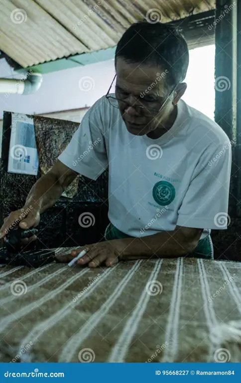 Gambar seorang pengrajin batik sedang membuat batik